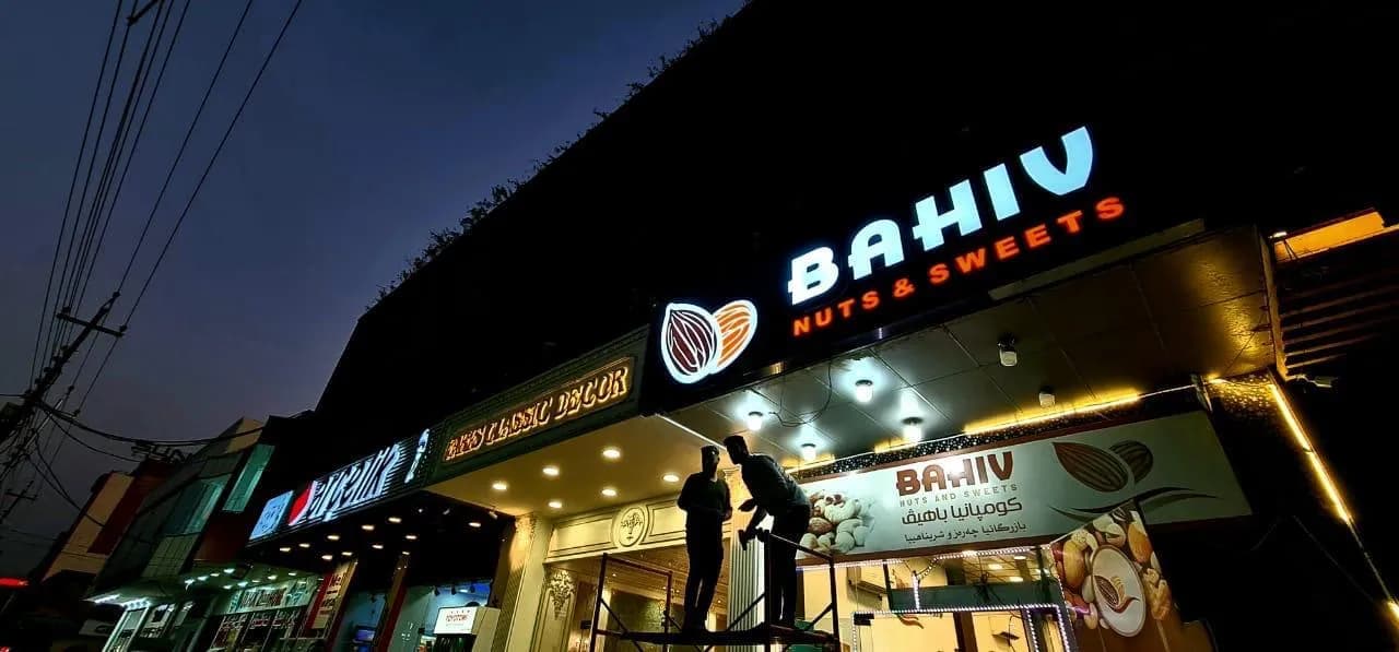 BAHIV Nuts & Sweets storefront lit up at night